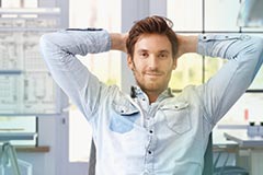 Man smiling with hands behind head