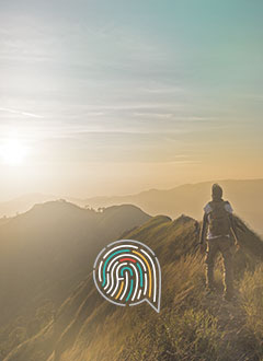 Man with backpack on top of green mountain